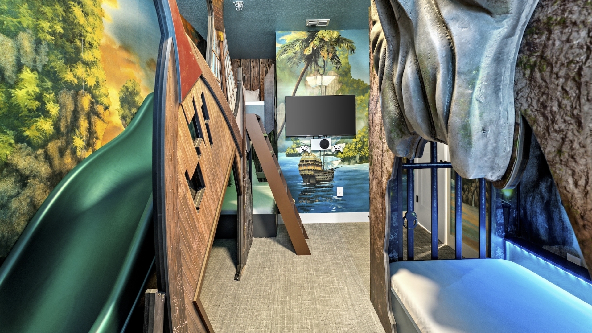 A pirate-themed children's bedroom featuring custom bunk beds shaped like a wooden ship and a stone jail cell, a green slide, and immersive tropical island wall murals.