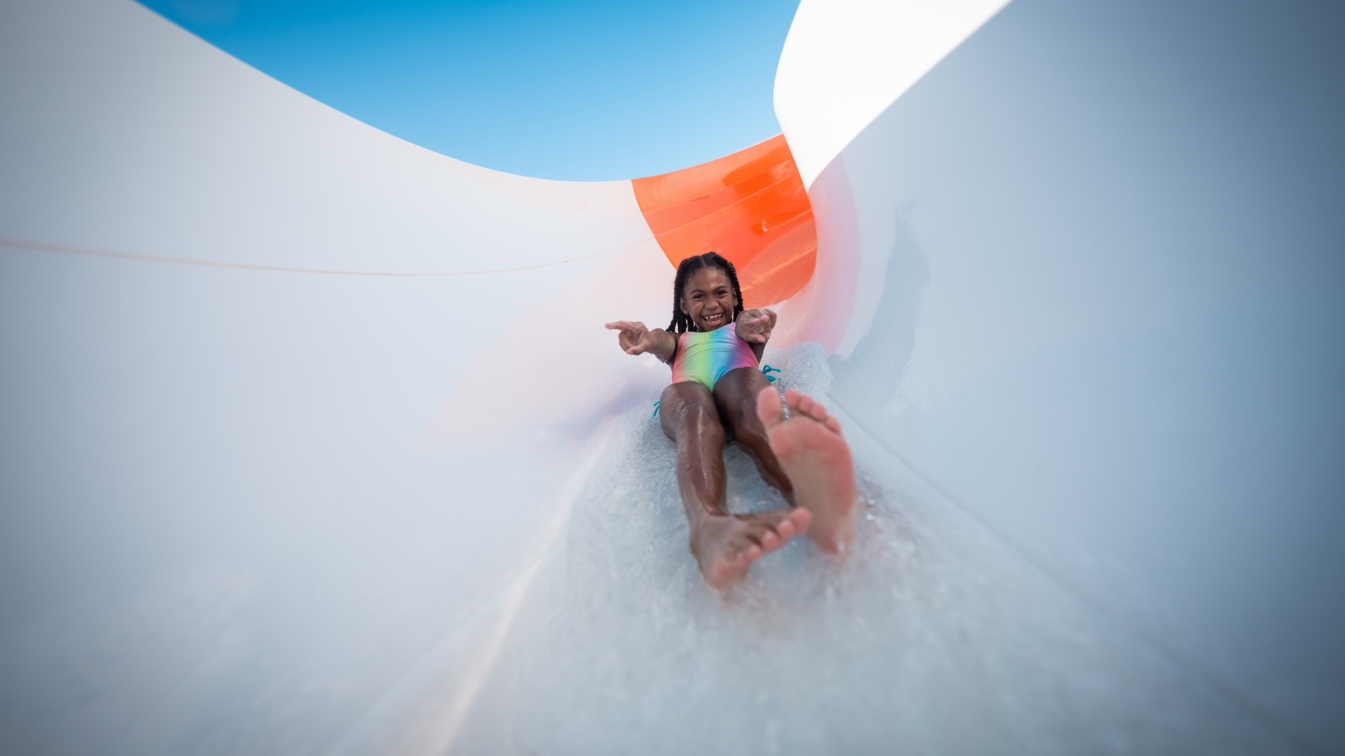 A girl riding a water slide